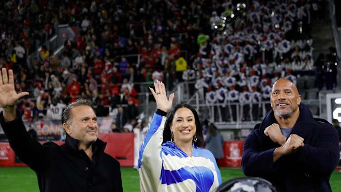 Feb 19, 2023; Washington, DC, USA; XFL co-owners Gerry Cardinale (L), Dany Garcia (M), and Dwayne Johnson (R) gestures to fans from the sideline during the game between the D.C. Defenders and the Seattle Sea Dragons in the second quarter at Audi Field. Mandatory Credit: Geoff Burke-USA TODAY Sports