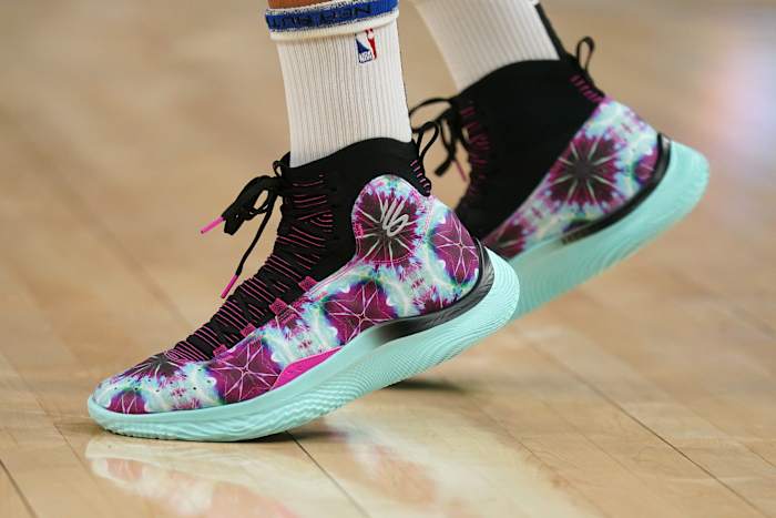 Golden State Warriors guard Stephen Curry's purple and green Under Armour sneakers.