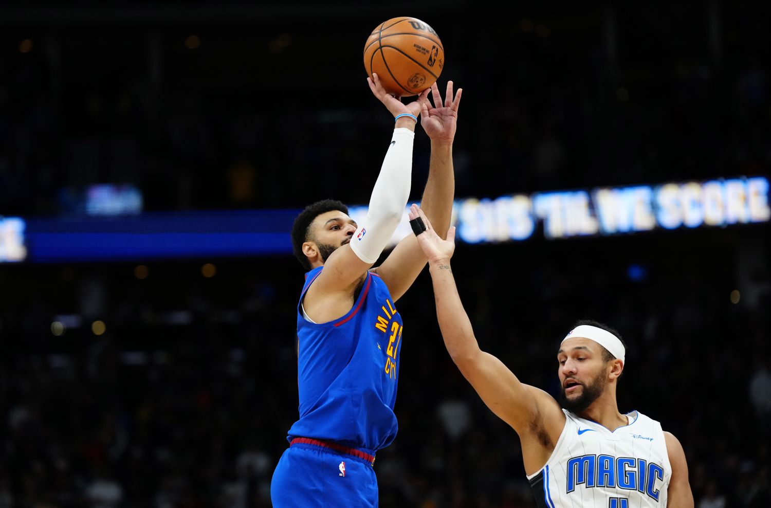Jalen Suggs attempting to block a shot by Jamal Murray.