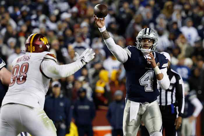 Dallas Cowboys quarterback Dak Prescott (4) passes the ball as Washington Commanders defensive tackle Phidarian Mathis (98) defends during the fourth quarter at FedExField.