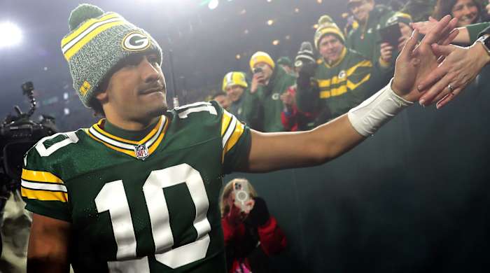 Jordan Love high fives fans in the stadium
