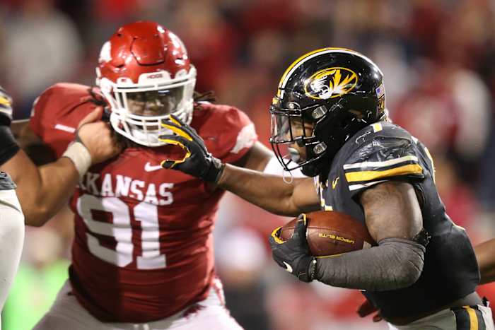 Nov 26, 2021; Fayetteville, Arkansas, USA; Missouri Tigers running back Tyler Badie (1) runs the ball as Arkansas Razorbacks defensive lineman Taurean Carter (91) defends in the second half at Donald W. Reynolds Razorbacks Stadium