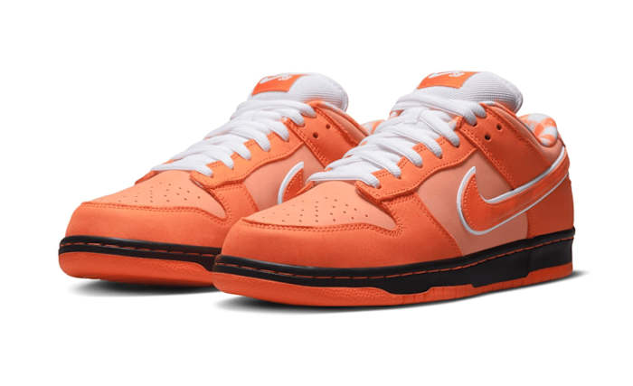 Side view of orange and white Nike Dunk sneakers.