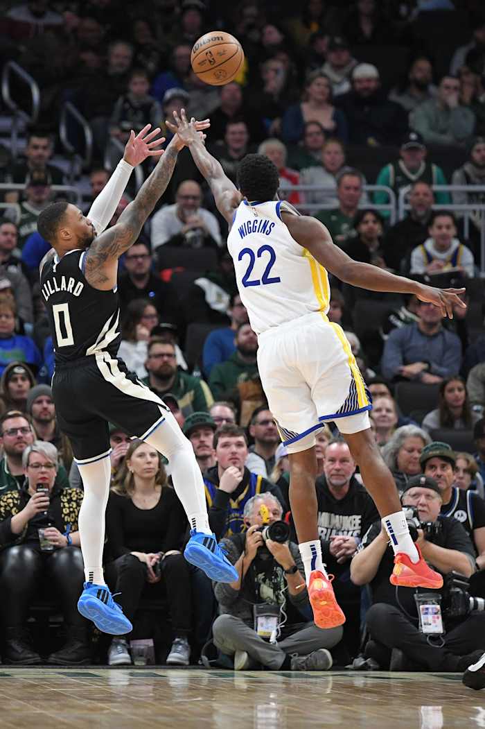 Milwaukee Bucks guard Damian Lillard (0) shoots the ball against Golden State Warriors forward Andrew Wiggins (22)