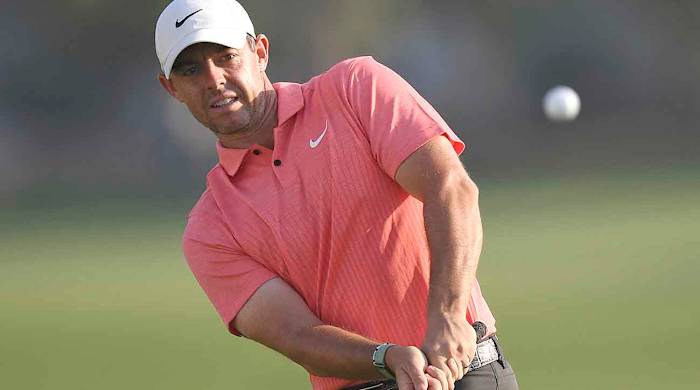 Rory McIlroy watches a pitch shot at the 2022 DP World Tour Championship.