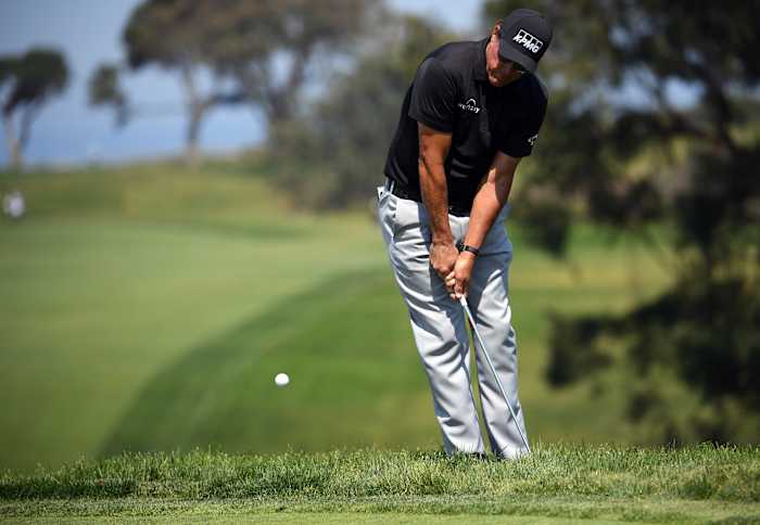 Phil Mickelson chips onto the 13th green during the U.S. Open's first round at Torrey Pines Golf Course.
