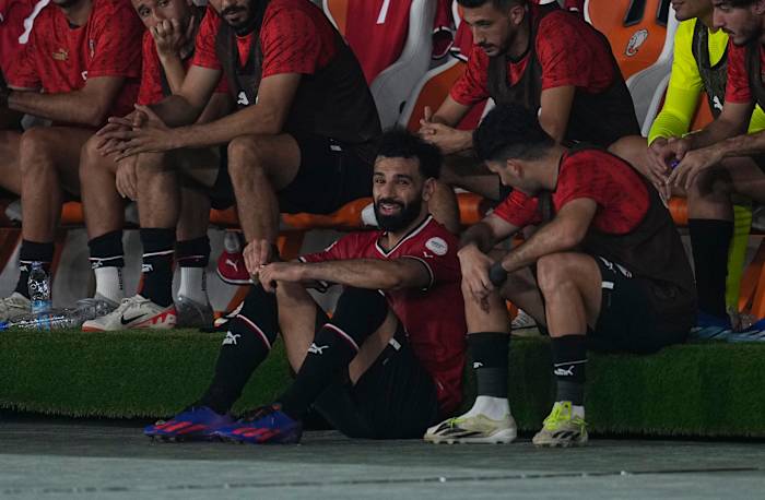 Egypt captain Mo Salah pictured (center) sat on the ground by his team's bench after being subbed off with an injury during a 2-2 draw against Ghana at the Africa Cup of Nations in January 2024