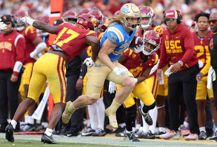 Nov 18, 2023; Los Angeles, California, USA; UCLA Bruins running back Carson Steele (33) is pushed out of bounds by USC Trojans cornerback Christian Roland-Wallace (17) during the first quarter at United Airlines Field at Los Angeles Memorial Coliseum. Mandatory Credit: Jason Parkhurst-USA TODAY Sports