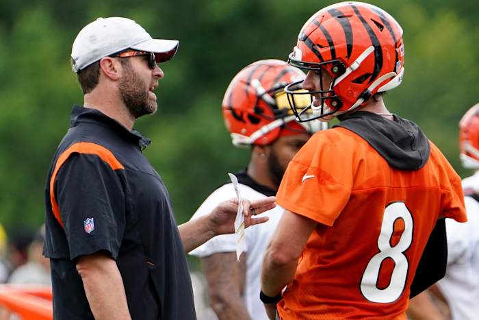 Cincinnati Bengals offensive coordinator Brian Callahan, left, talks with Cincinnati Bengals quarterback Brandon Allen (8), right, during Cincinnati Bengals training camp practice, Monday, Aug. 1, 2022, at the practice fields next to Paul Brown Stadium in Cincinnati.