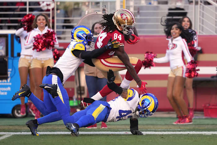 Jan 7, 2024; Santa Clara, California, USA; San Francisco 49ers wide receiver Chris Conley (84) is tackled by Los Angeles Rams cornerback Derion Kendrick (left) and safety John Johnson III (bottom) during the second quarter at Levi's Stadium. (Darren Yamashita / USA TODAY Sports).