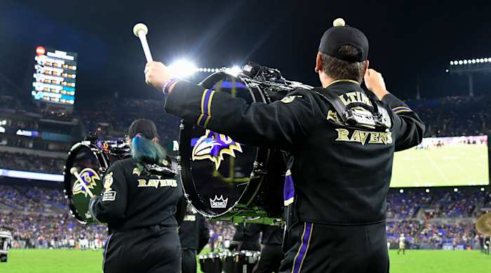 Baltimore Ravens marching band run on the field during a game