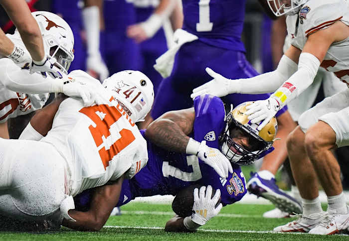 Texas Longhorns linebacker Jaylan Ford (41) brings down Washington Huskies running back Dillon Johnson (7) in the second quarter of the Sugar Bowl College Football Playoff semi-finals at the Ceasars Superdome in New Orleans, Louisiana, Jan. 1, 2024. The Texas Longhorns take on the Washington Huskies for a spot in the College Football Playoff Finals.