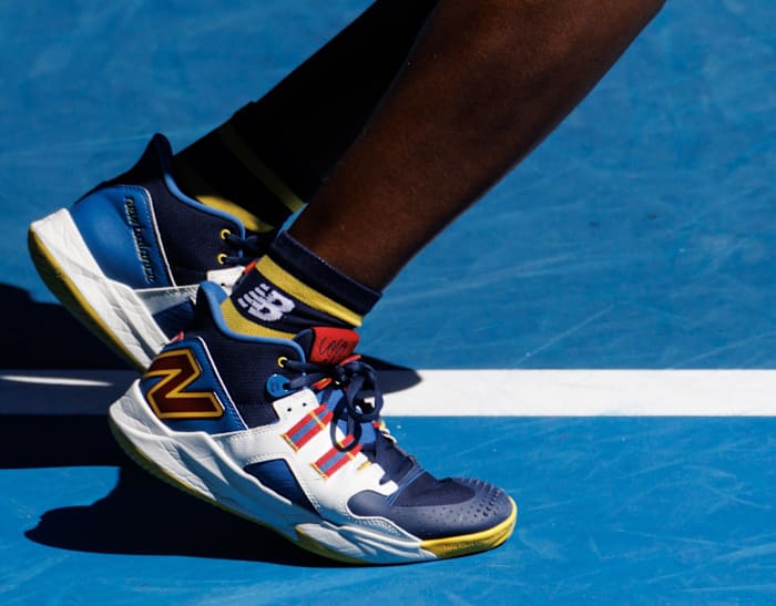 Coco Gauff's navy, white, and yellow New Balance tennis shoes.