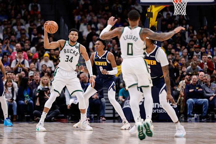 Milwaukee Bucks forward Giannis Antetokounmpo (34) catches a pass from guard Damian Lillard (0) as Denver Nuggets forward Peyton Watson (8) and guard Kentavious Caldwell-Pope (5) defend