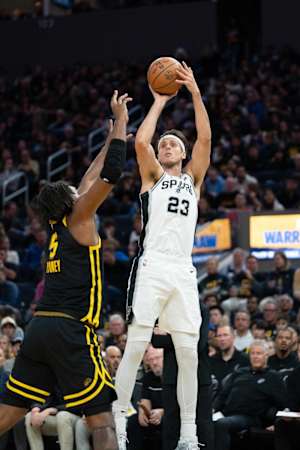 November 24, 2023; San Francisco, California, USA; San Antonio Spurs forward Zach Collins (23) shoots the basketball against Golden State Warriors forward Kevon Looney (5) during the second quarter at Chase Center.