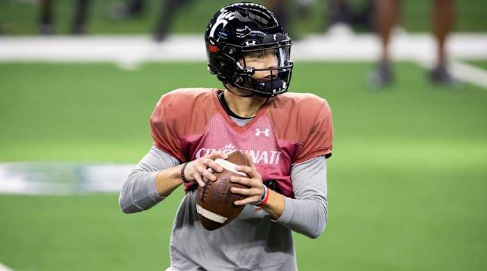 Cincinnati quarterback Desmond Ridder looks for an open receiver during practice for the Cotton Bowl NCAA football game, Monday, Dec. 27, 2021, in Arlington, Texas.