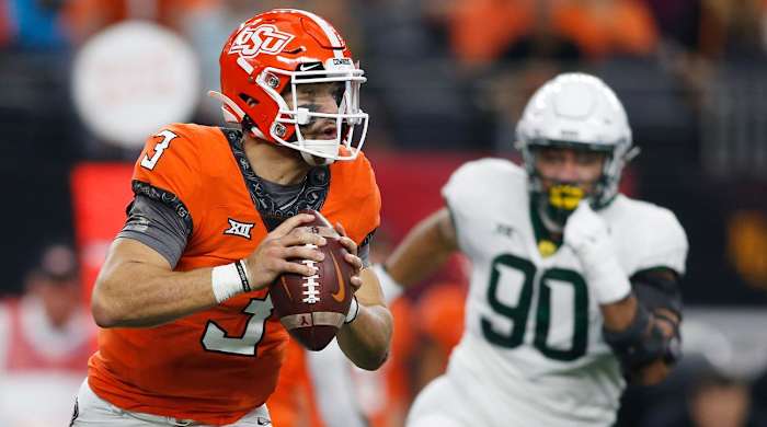 Oklahoma State quarterback Spencer Sanders (3) rolls out to pass while chased by Baylor defensive lineman TJ Franklin (90) in the first half of an NCAA college football game for the Big 12 Conference championship in Arlington, Texas, Saturday, Dec. 4, 2021.