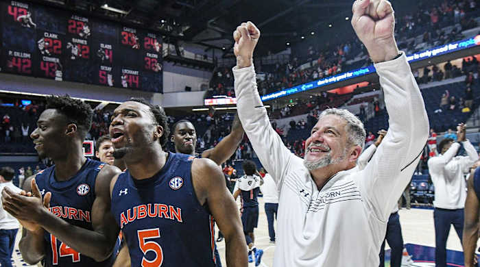 Auburn guard Preston Cook (14), forward Chris Moore (5), and head coach Bruce Pearl celebrate a win over Mississippi in an NCAA college basketball game in Oxford, Miss., Saturday, Jan. 15, 2022.