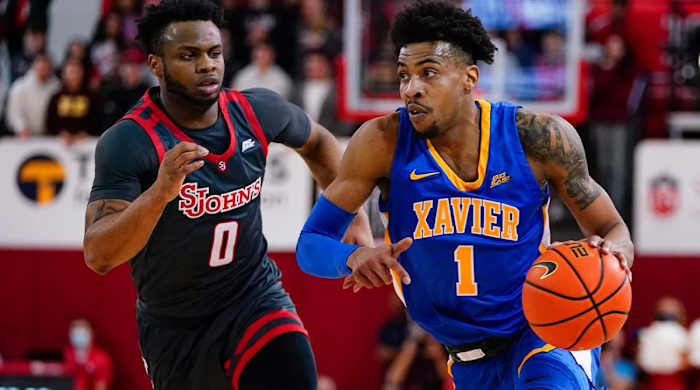 Xavier’s Paul Scruggs (1) drives past St. John’s Posh Alexander (0) during the first half of an NCAA college basketball game Wednesday, March 2, 2022, in New York.
