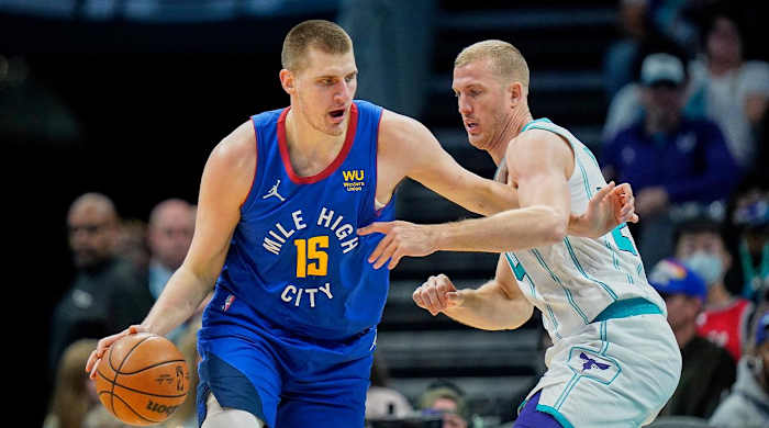 Denver Nuggets center Nikola Jokic (15) goes to the basket against Charlotte Hornets center Mason Plumlee, right, during the first half of an NBA basketball game on Monday, March 28, 2022, in Charlotte, N.C.