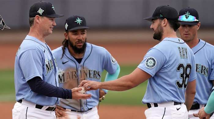 Seattle Mariners manager Scott Servais, left, takes the ball from starting pitcher Robbie Ray (38) after making a pitching change during the fifth inning of a spring training baseball game against the Texas Rangers Monday, March 28, 2022, in Peoria, Ariz.