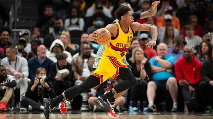 Atlanta Hawks forward De’Andre Hunter (12) drives past Brooklyn Nets forward James Johnson, behind, during the second half of an NBA basketball game Saturday, April 2, 2022, in Atlanta.