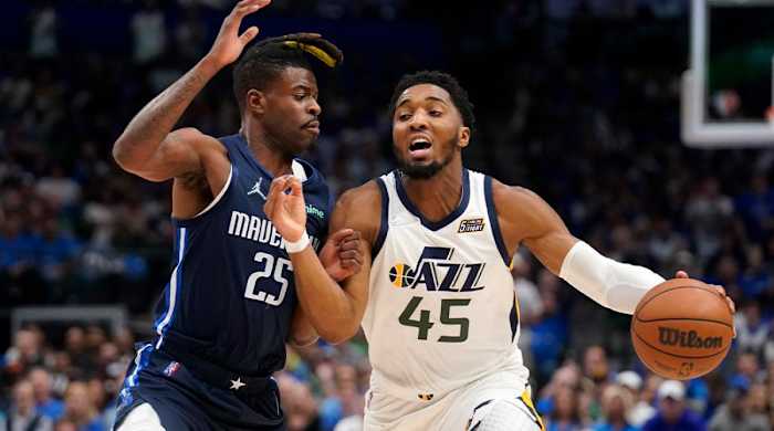 Dallas Mavericks forward Reggie Bullock (25) defends as Utah Jazz guard Donovan Mitchell (45) works to the basket in the first half of Game 1 of an NBA basketball first-round playoff series, Saturday, April 16, 2022, in Dallas.