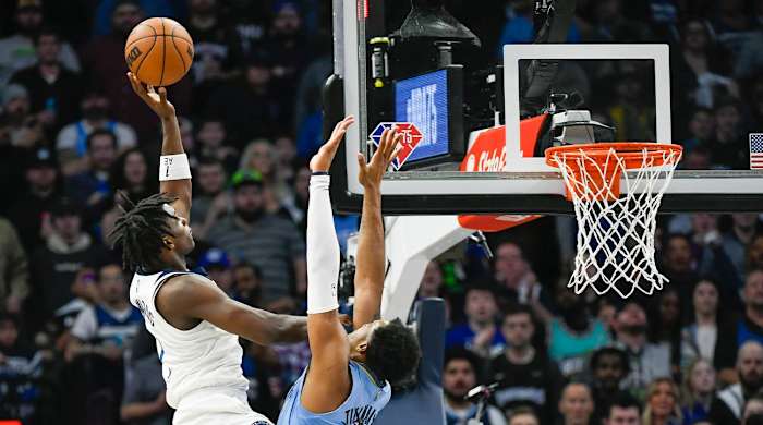 Minnesota Timberwolves guard Anthony Edwards, left, shoots over Memphis Grizzlies forward Xavier Tillman during the first half in Game 4 of an NBA basketball first-round playoff series Saturday, April 23, 2022, in Minneapolis.