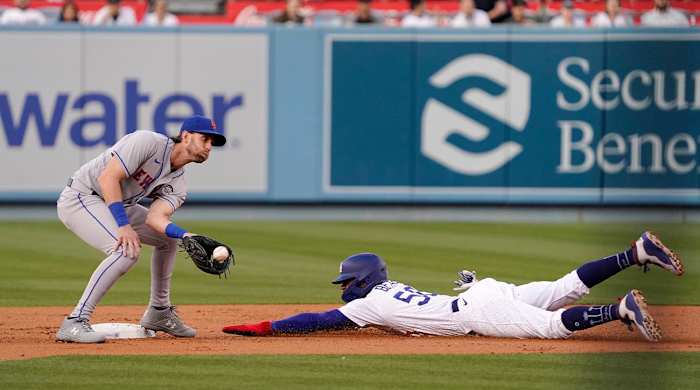 Los Angeles Dodgers’ Mookie Betts, right, steals second as New York Mets second baseman Jeff McNeil takes a late throw during the first inning of a baseball game Thursday, June 2, 2022, in Los Angeles.