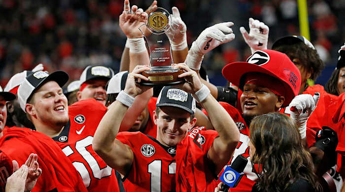Georgia quarterback Stetson Bennett raises the SEC Championship MVP trophy after a victory against LSU.