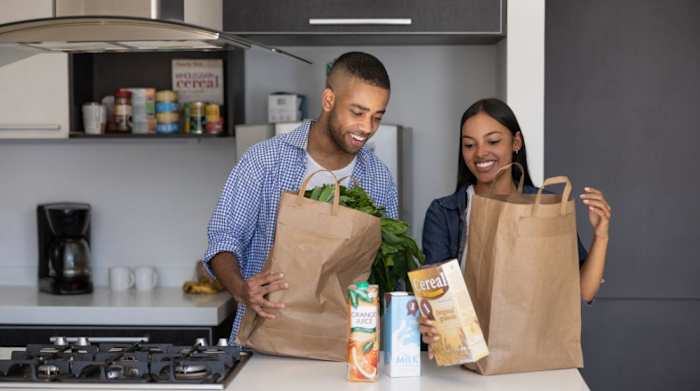 A man and woman in a kitchen unloading their grocery delivery service