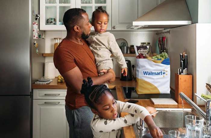 A family in a kitchen putting away their Walmart+ grocery delivery service food items
