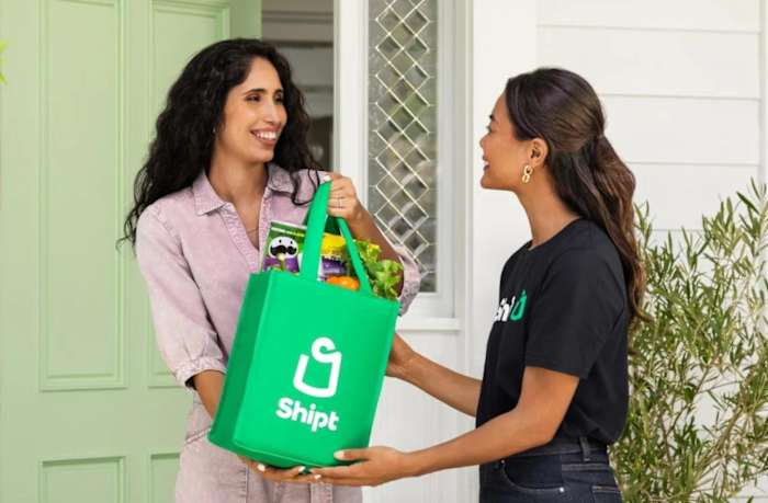 A woman delivering a bag of Shipt grocery items to another woman