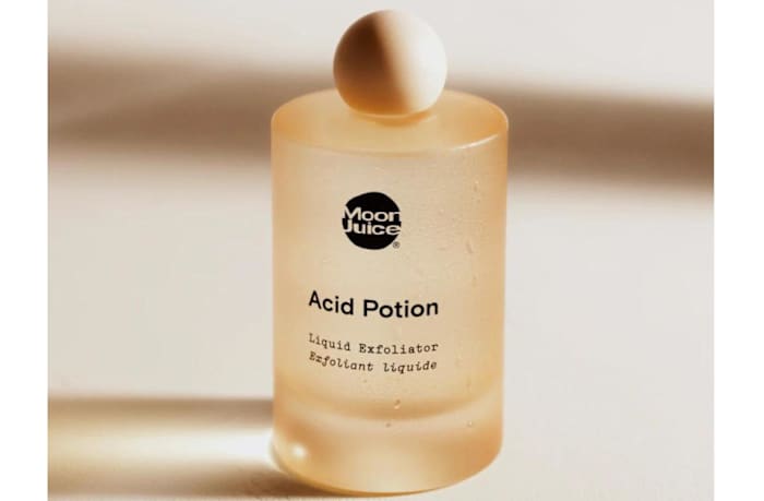 A light orange glass bottle of Moon Juice Acid Potion