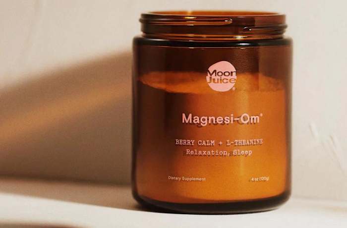 An amber-colored glass container of Moon Juice Magnesi-Om