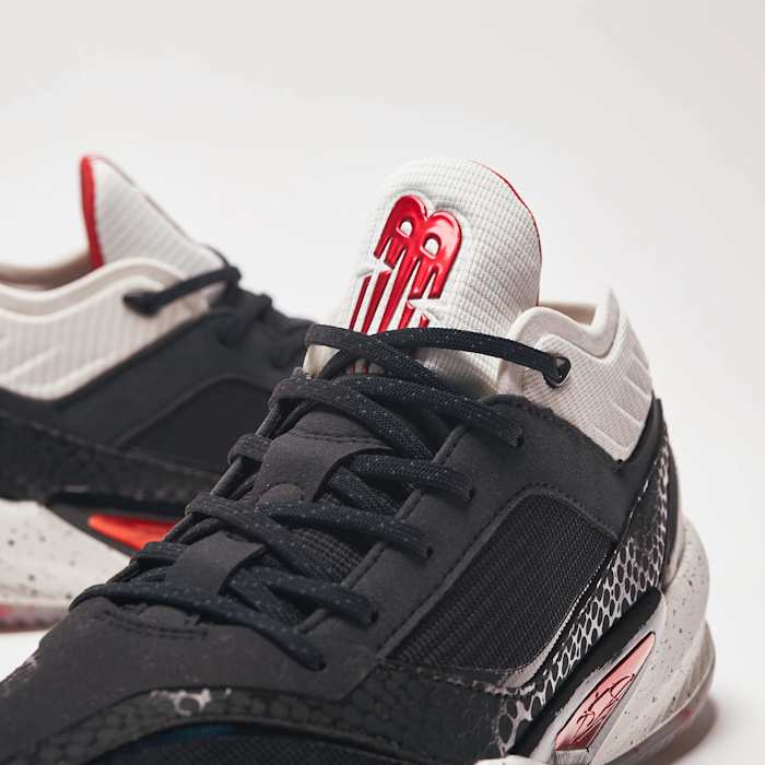 Detailed look white, red, and black New Balance shoes.