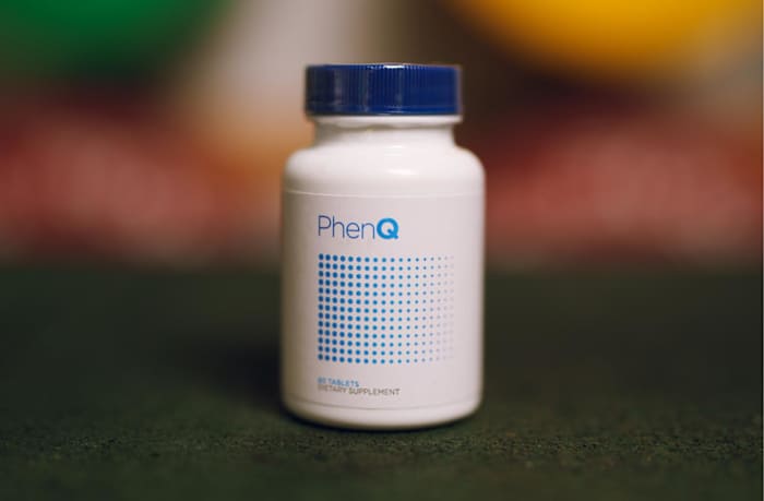 A white bottle with a blue writing and a blue top of PhenQ, a thermogenic supplement and appetite suppressant