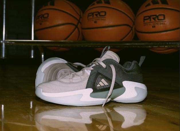 Side view of black and white adidas women's basketball shoes.