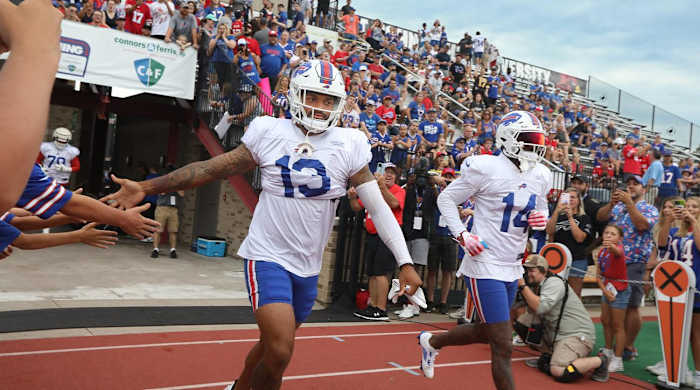 Bills receiver Gabe Davis (13), left, high-fives fans as he runs onto the field with Stefon Diggs (14), right, on day nine of Buffalo Bills training camp at St. John Fisher University in Rochester Thursday, Aug. 4, 2022.