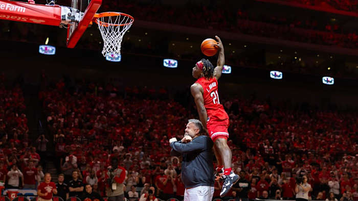 Nebraska running back Emmett Johnson attempts to dunk over head coach Matt Rhule at halftime of the Nebraksa-Minnesota men's basketball game (Feb. 25, 2024)