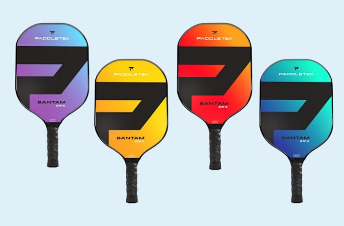 Four Paddletek New Era Bantam EX-L pickleball paddles, all with black handles and a purple and blue gradient hitting surface, yellow and orange gradient hitting surface, red and orange gradient hitting surface, and a teal and blue gradient hitting surface.