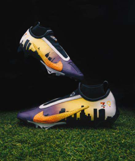 Side view of Dorian Singer's custom purple and orange Nike cleats.