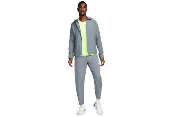 A man wearing a nike miler mens jacket in gray