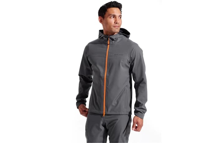 A man wearing a Pearl Izumi men's summit jacket in grey with an orange zip.
