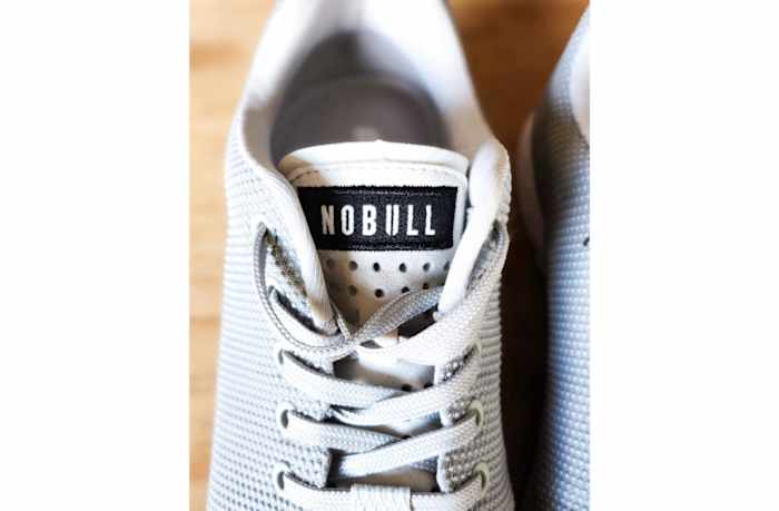 nobull-trainer-gray-birdseye-view-close-up-tongue-laces-upper-wood-background