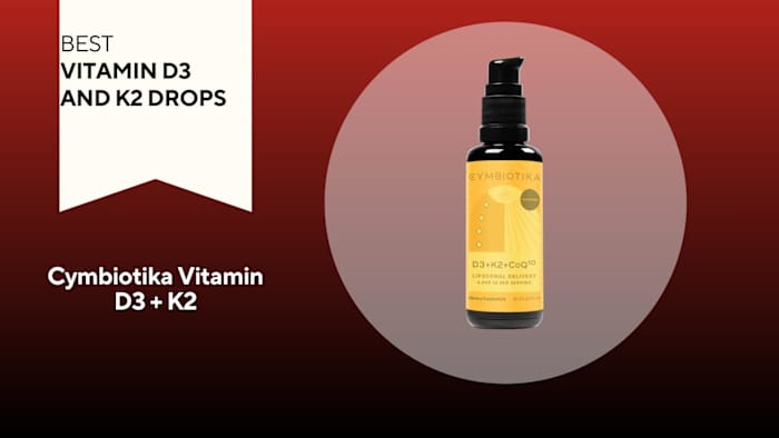 A pump bottle of Cymbiotika Vitamin D3 + K2 is pictured against a red background