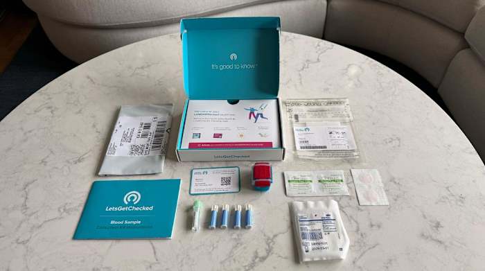 The LetsGetChecked Cholesterol Test kit components on a white and grey marble surface.