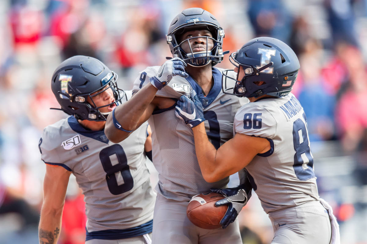 Illinois wide receiver Josh Imatorbhebhe (9) celebrates a touchdown with wide receiver Casey Washington (8) and wide receiver Donny Navarro (86) during a game against Wisconsin at Memorial Stadium.