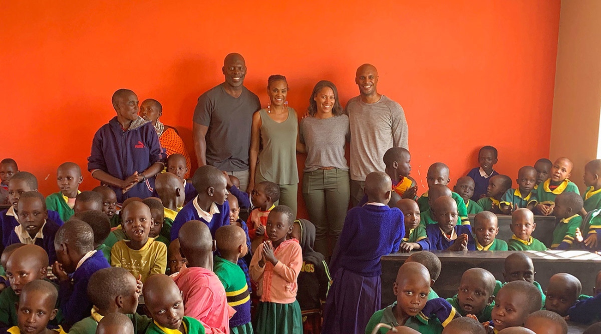 Anthony Lynn (left, standing), Stacey Lynn, Danielle Lynn and D’Anton Lynn stand in a classroom of the school.