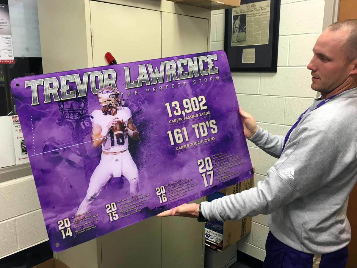Cartersville High coach Joey King holds an illustration he had made of Trevor Lawrence's accomplishments in four years as Cartersville's starting quarterback.